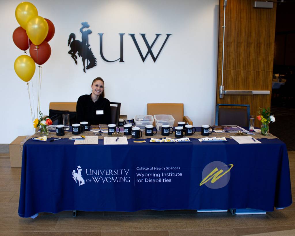 A welcoming WIND employee sitting at a registration table.