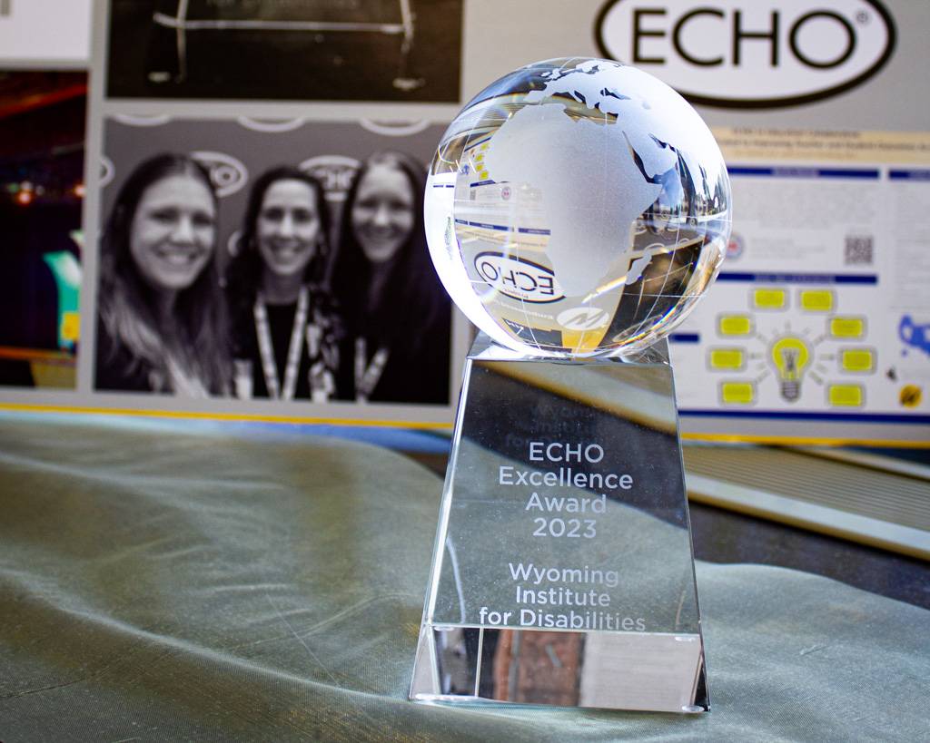 ECHO Excellence Award standing in front of an ECHO poster.