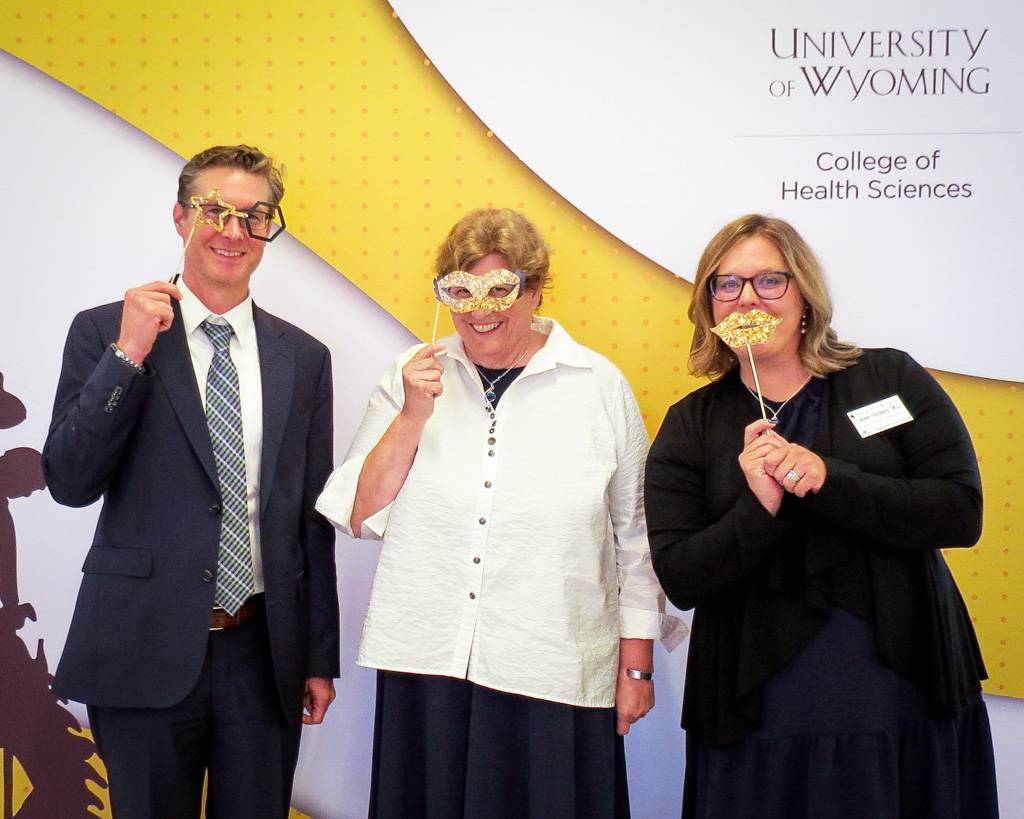 Eric Moody and Canyon Hardesty posing with colorful props with Keith Miller Awardee, Sandy Root-Elledge.
