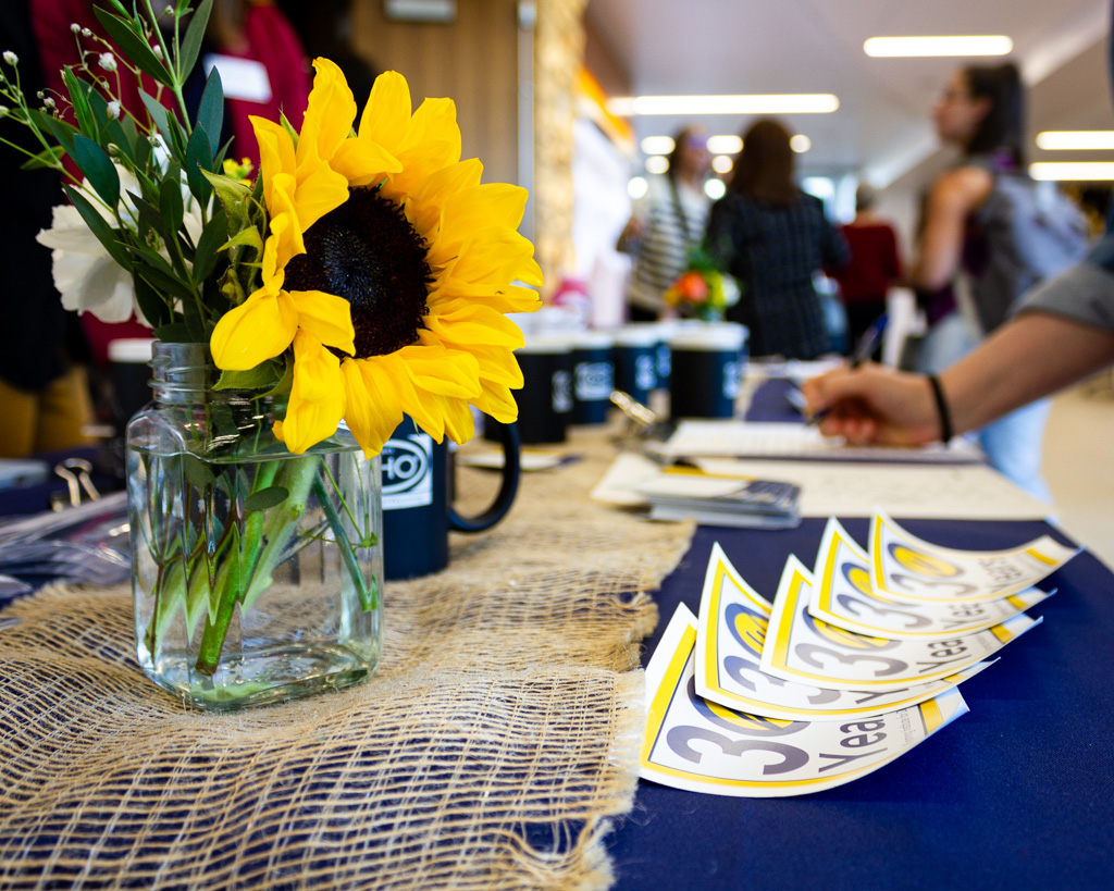 A table covered in 30th Anniversary stickers and flowers