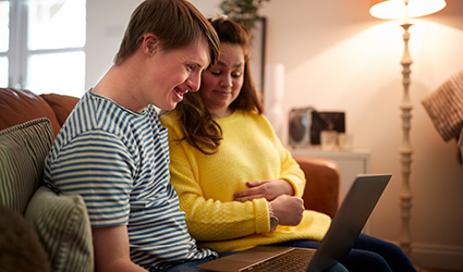 two people reading something on a laptop