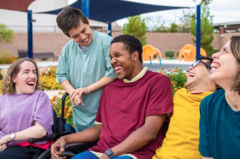 A group of students laughing together on a college campus