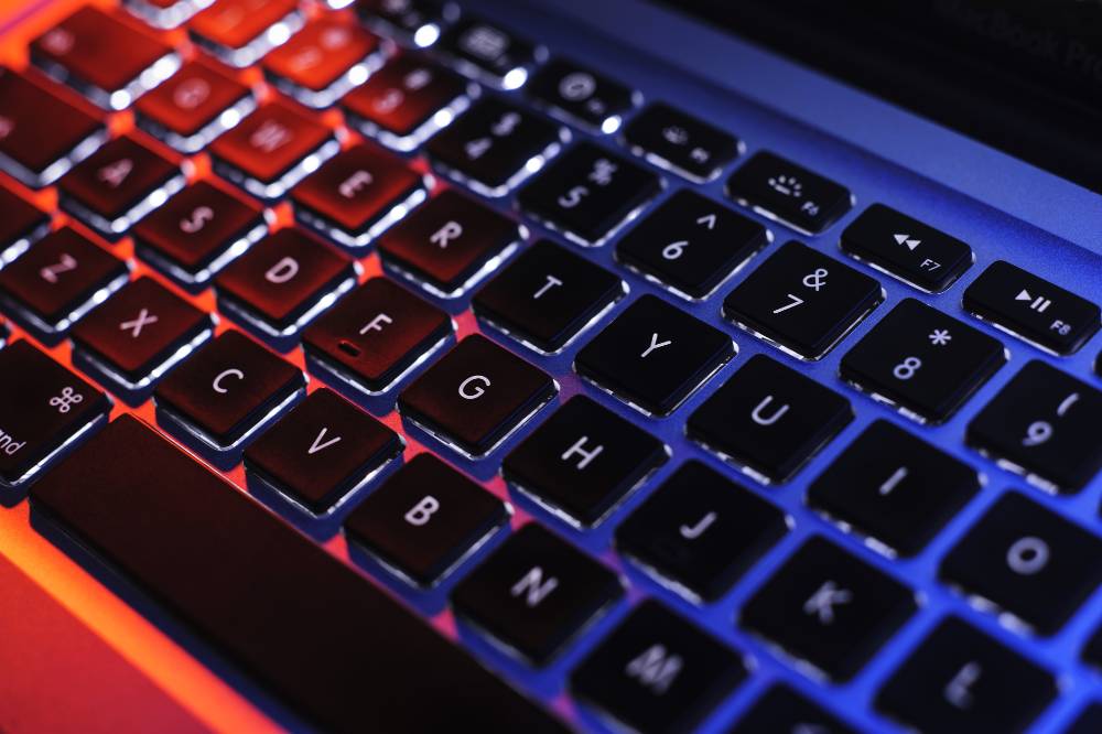 A computer keyboard backlit with colorful LEDs