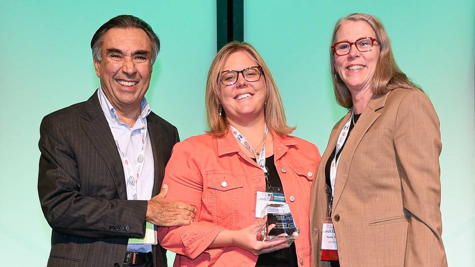Canyon Hardesty poses with ECHO founder holding the ECHO excellence award