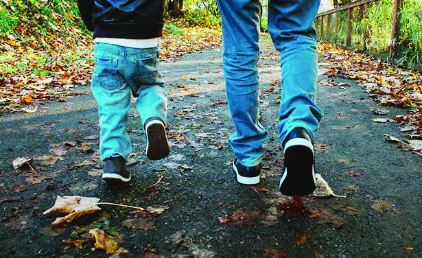 father and son walking away from the camera