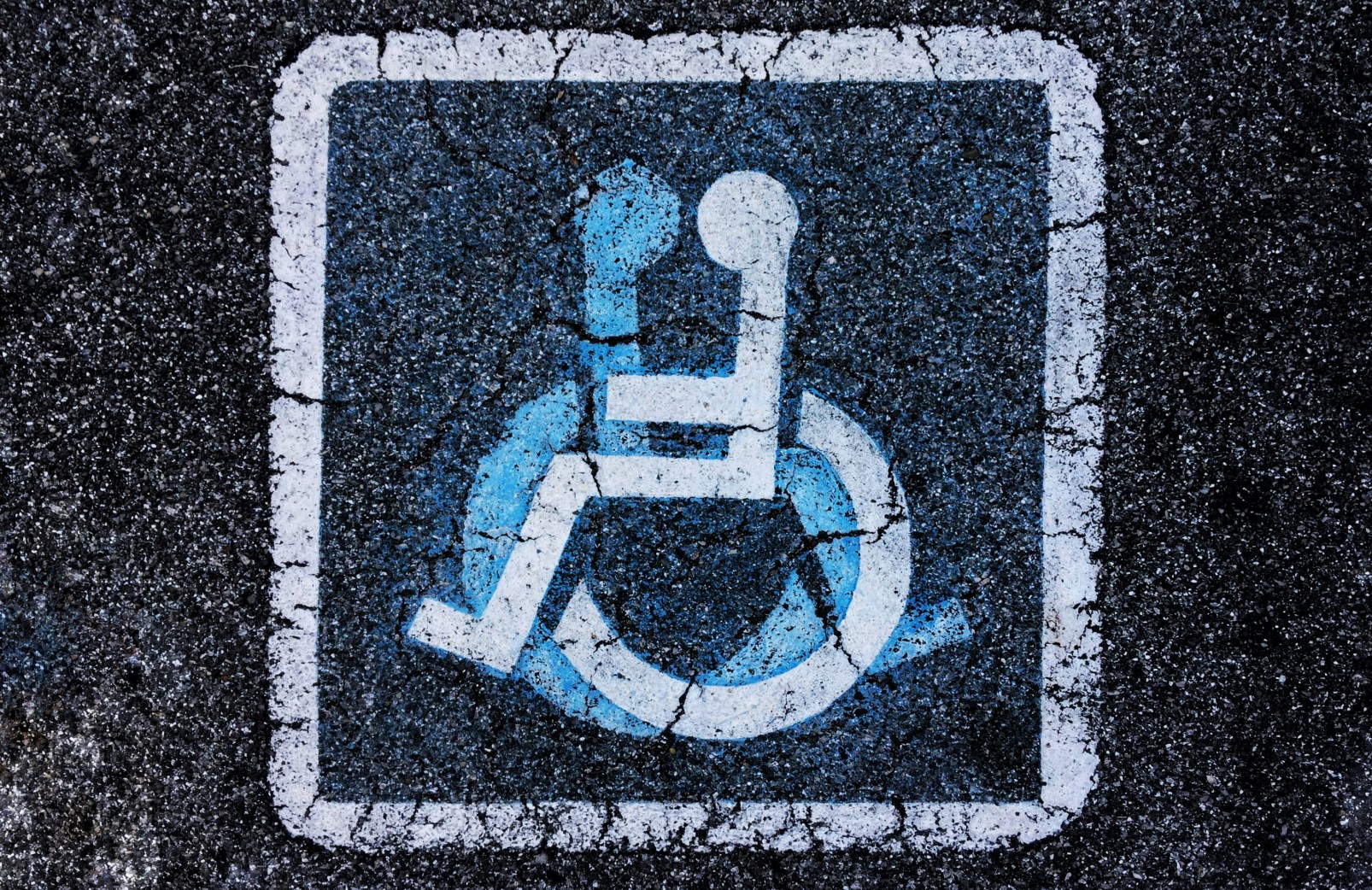 Two handicap icons over lapping on pavement.