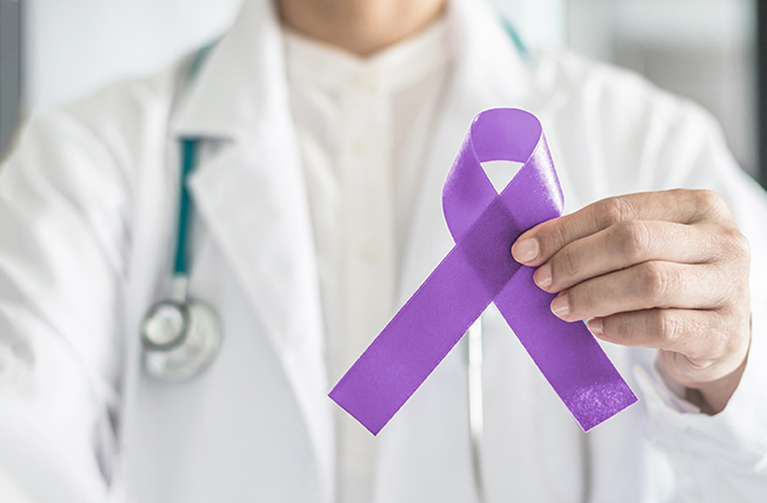 purple ribbon being held by physician