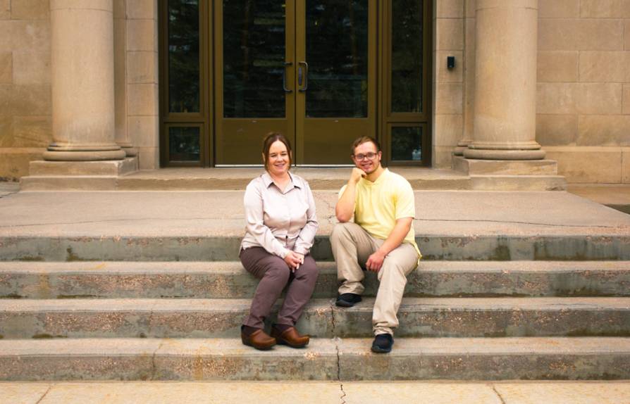 A WIND employee and IPSE student sitting on the steps of UWyo Health Sciences