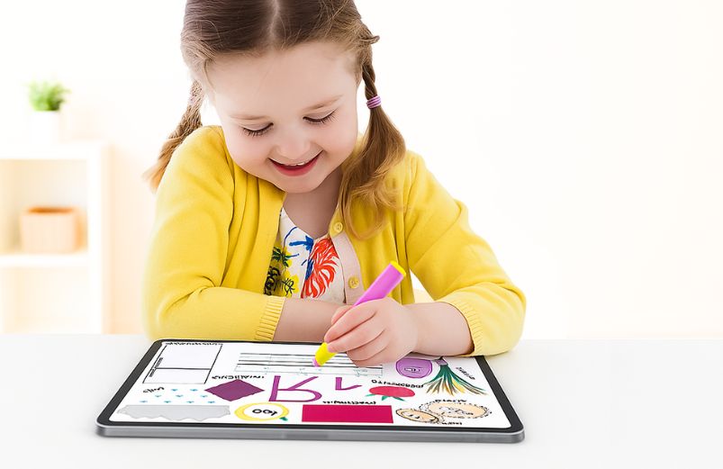 A young girl tracing letters with a stylus and ipad