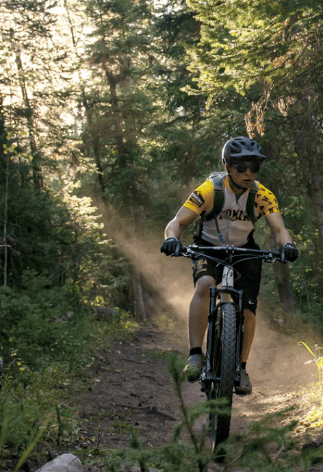 Person riding a bike on a trail in the forest