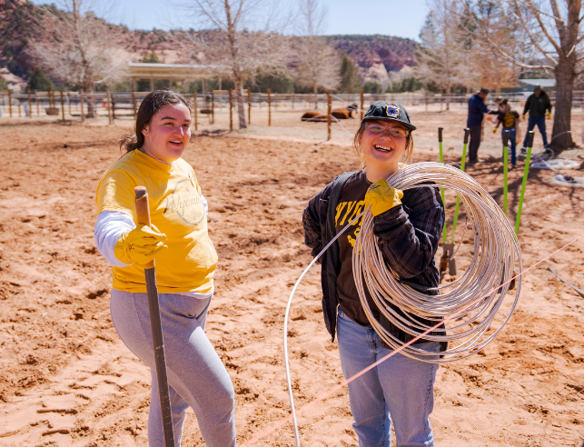 Students smile as they work together outside