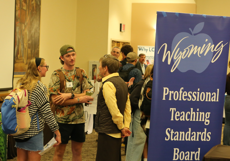 Photo of College of Education students talking to District Residency Connections Fair founder Elizabeth McMahan.