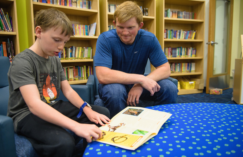 Student learning to read with a student teacher.