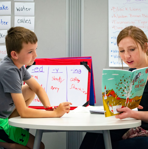 Photo of teacher reading to a student.