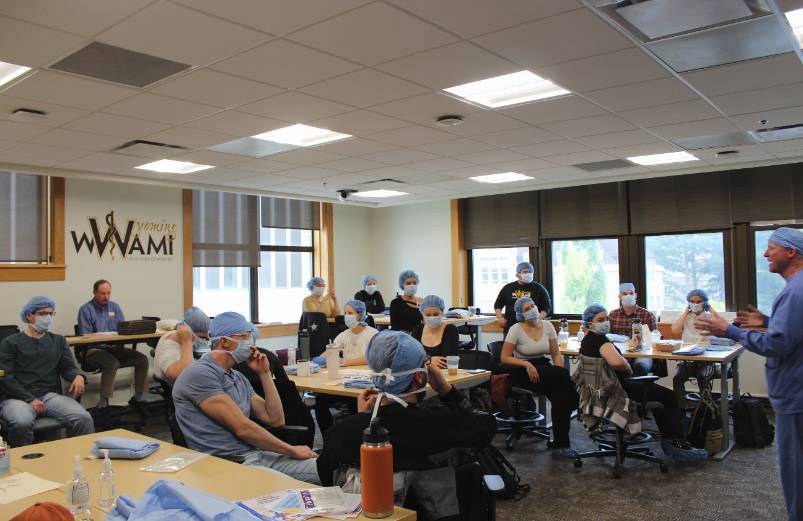 A classroom with several people wearing scrubs.
