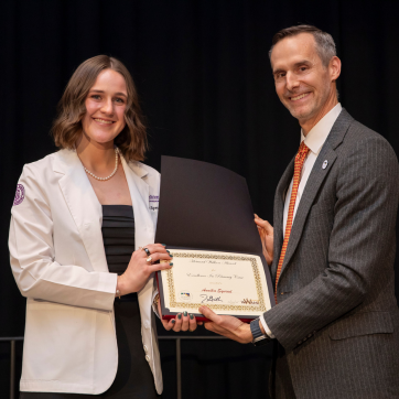 Smiling student being presented with an award
