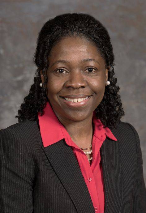 Natalia Brown, wearing a black and silver suit jacket and a pink blouse.