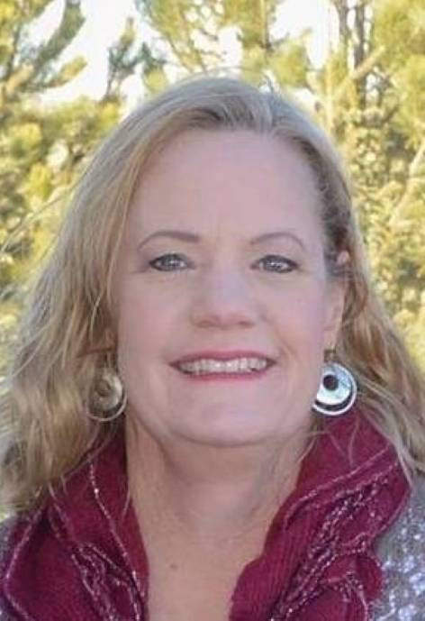 Deb Dolph, wearing a sliver blouse with a dark pink scarf.