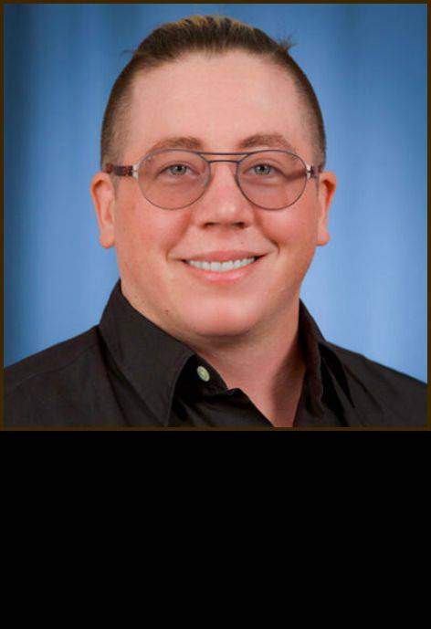 Dr. Liam Clark, wearing a black button-up shirt.