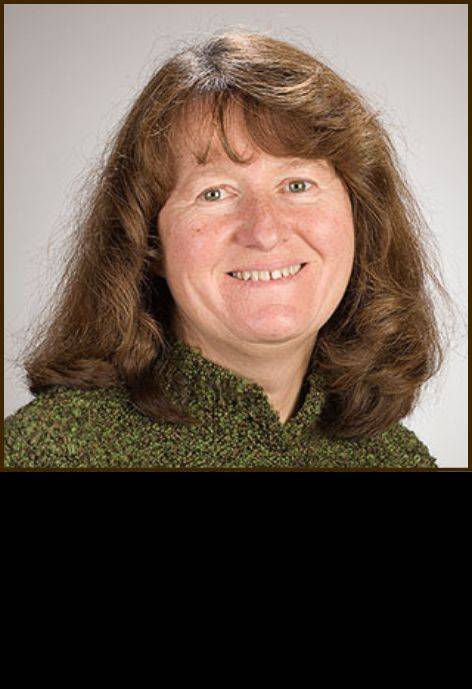 Dr. Carol Fischer, wearing a forest green sweater.