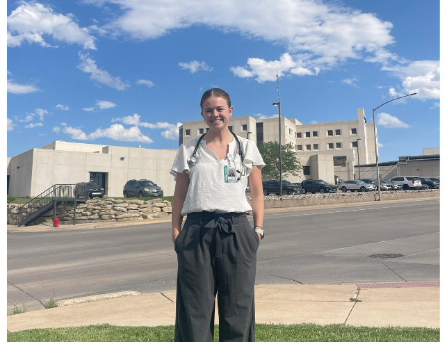 Student doctor stood outside a hospital.