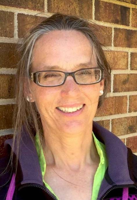 Brenda Alexander, wearing a black and purple fleece jacket with a lime green shirt underneath.