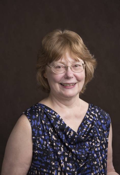 Pam Langer, wearing a blue, black, and silver blouse.