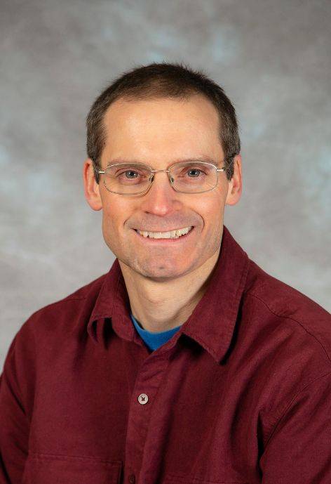 Brian Menkhaus, wearing a dark red button-up shirt.