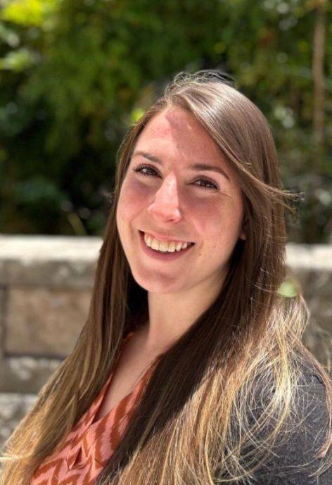 Liz Quigley, wearing a black suit jacket and a peach-colored blouse.