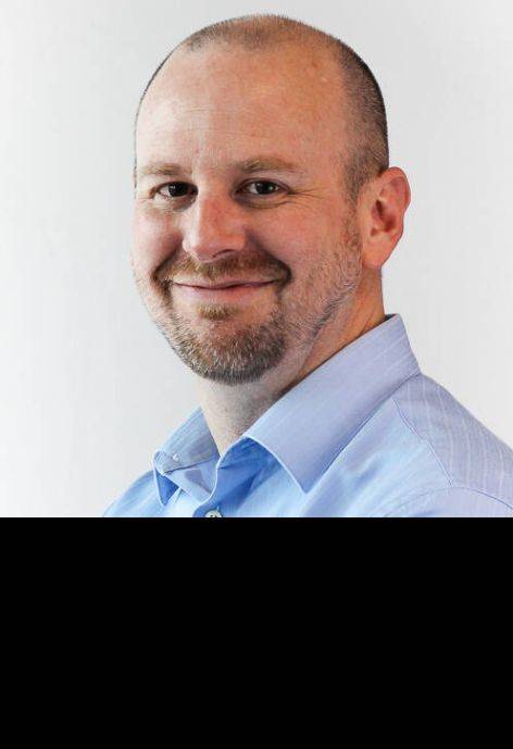 Nathan Valencia Still, wearing a light-blue button-up shirt.