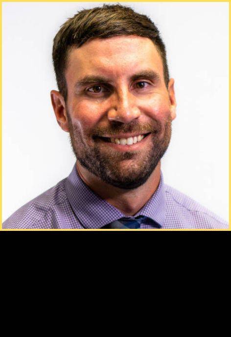 Dr. Tyler Gallo, wearing a light purple button-up shirt and a blue tie.