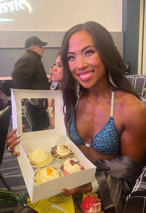 Daphne holding up a box with desserts in it.