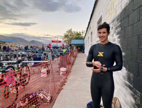 Casey at a bike race, he is wearing a black body suit.
