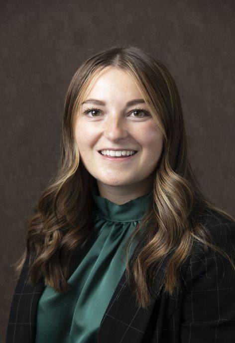 McKenzie Stampfli wearing a black suit jacket and a dark green blouse.