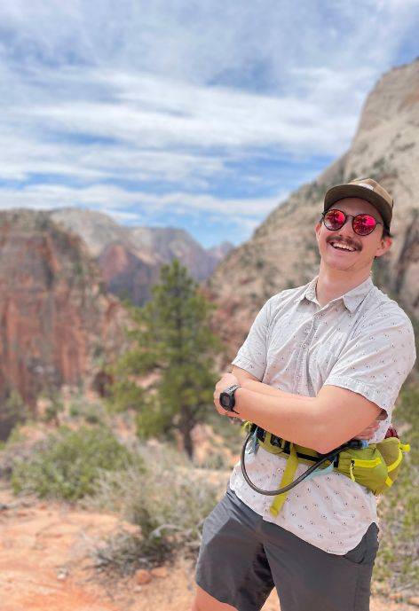 Galen hiking in a red stone colored valley.