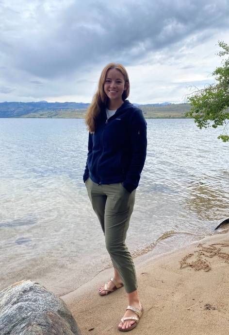 Sabrina standing on the shore of a lake.