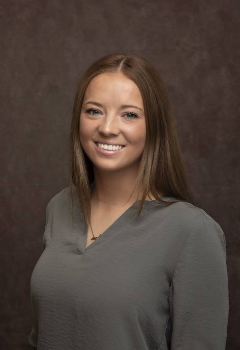 Sabrina Gay wearing a grey blouse.