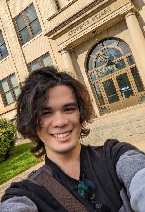 Dean taking a selfie in front of UW's Health Sciences building.