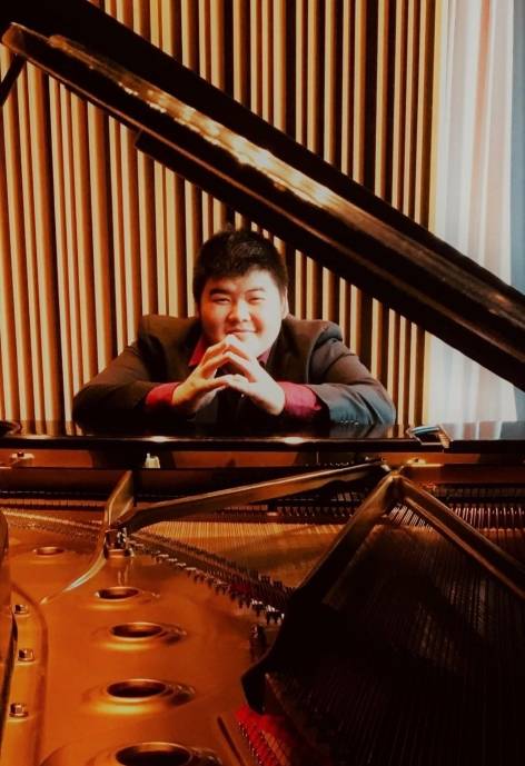 Kit sitting at a piano.