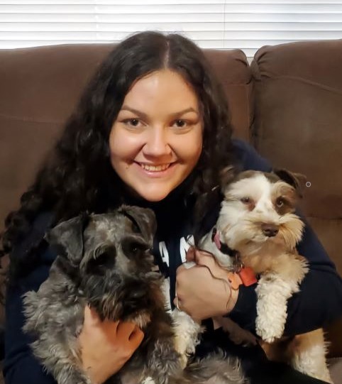 Celeste holding two small dogs.