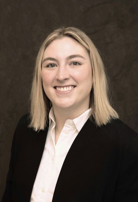 Jill Mayer wearing a black jacket and white button-up shirt.