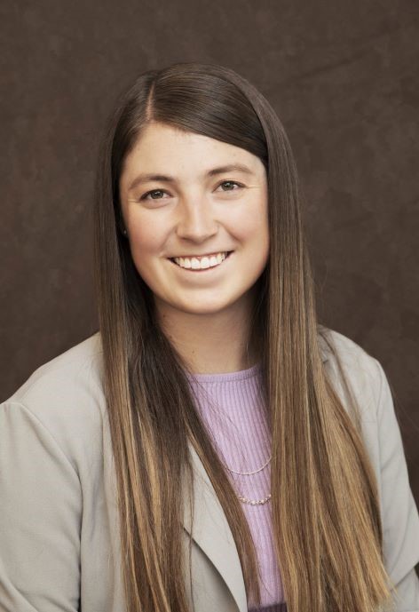 Shay Nelson wearing a light grey jacket and a lavendar blouse.