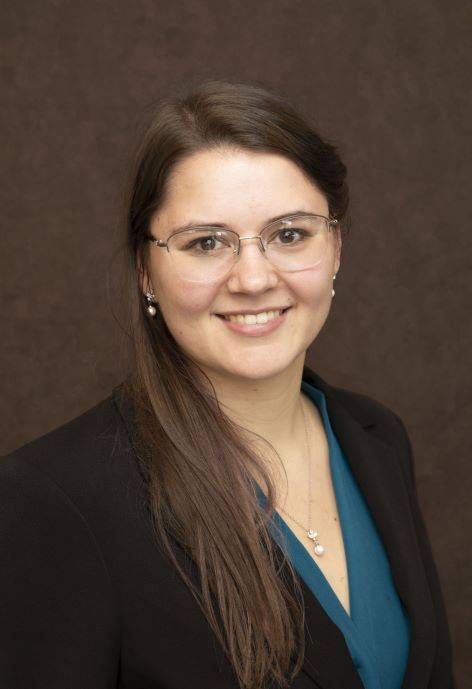 Hannah Thomas wearing a black suit jacket and a teal blouse.