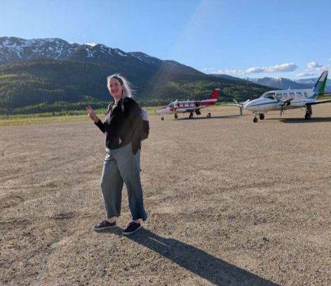 Samantha standing on a dirt air field.