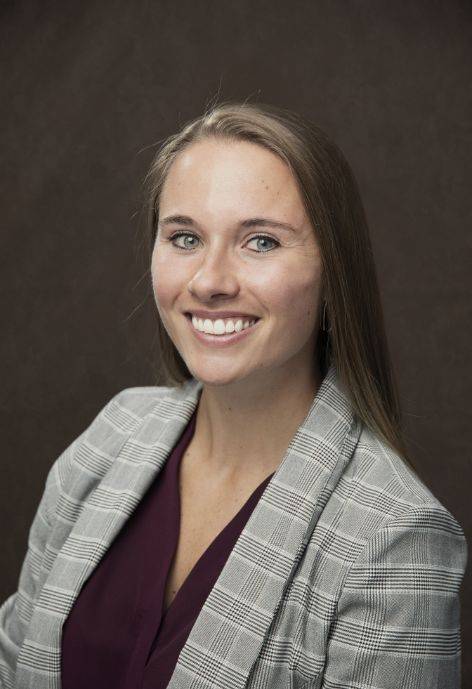 Ali Lange wearing a plaid blazer and wine colored blouse.