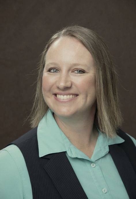 Cherol Minton wearing a black pin-strip vest and a seafoam green button-up.