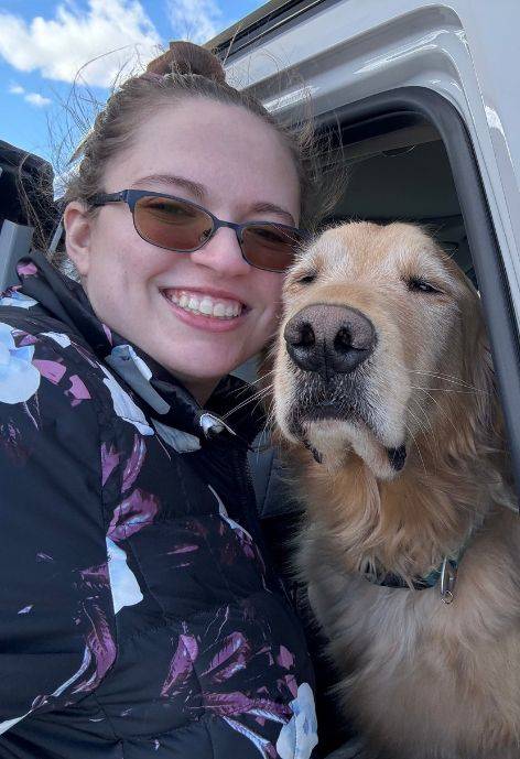 Gabrielle taking a selfie with a golden retriever dog.