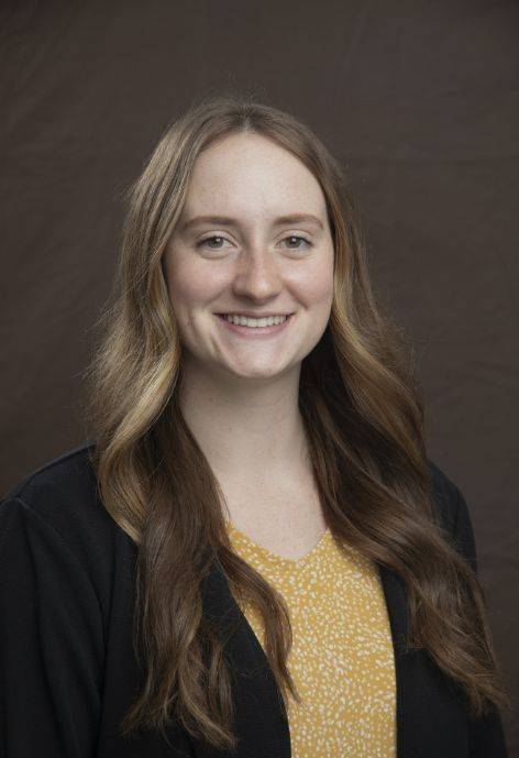Zoe Robison wearing a black blaszor and a yellow blouse.