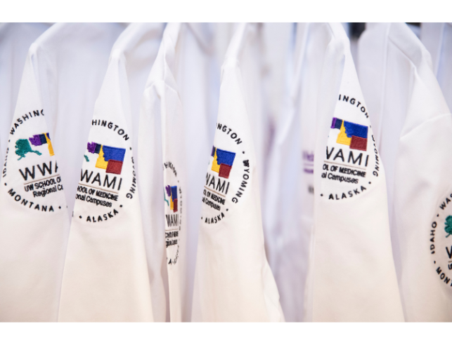 A line of doctor's coats with WWAMI embroidered on them.