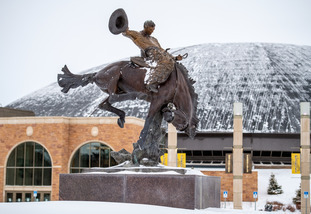 The Bucking Horse statue stands amid snow in front of the Arena Auditorium.